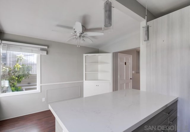 kitchen featuring ceiling fan, dark hardwood / wood-style flooring, hanging light fixtures, and lofted ceiling