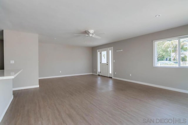 unfurnished living room featuring dark hardwood / wood-style floors and ceiling fan