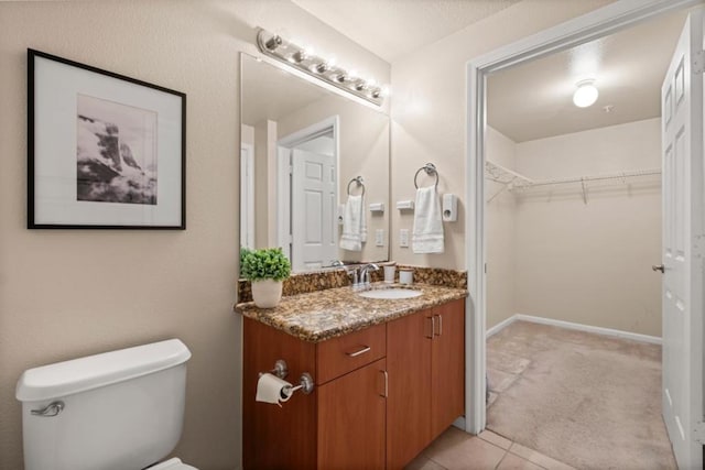 bathroom with tile patterned flooring, vanity, and toilet