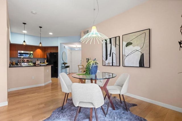 dining space with light hardwood / wood-style flooring