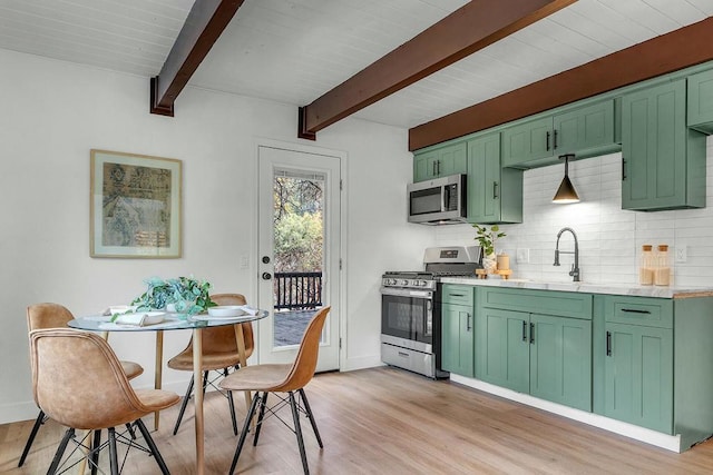 kitchen with light hardwood / wood-style flooring, sink, appliances with stainless steel finishes, and green cabinetry