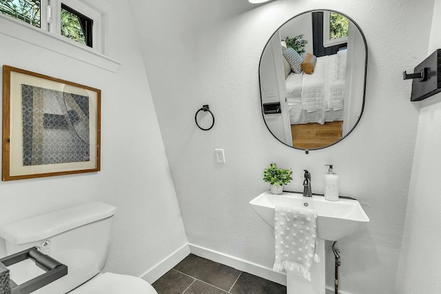 bathroom featuring tile patterned floors, a healthy amount of sunlight, and toilet