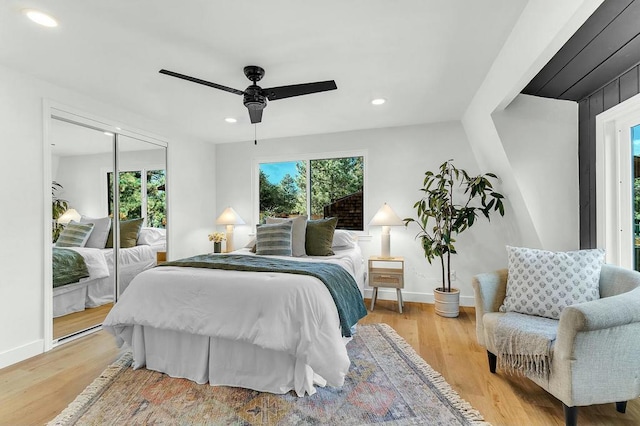 bedroom featuring ceiling fan, light hardwood / wood-style flooring, and a closet