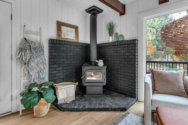 interior details featuring a wood stove, wooden walls, and wood-type flooring