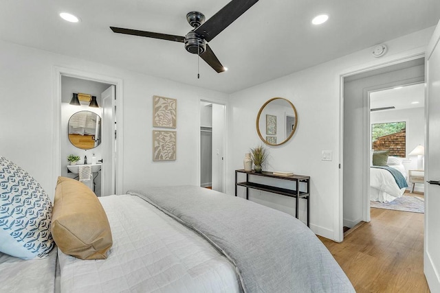 bedroom with ceiling fan, ensuite bathroom, and light hardwood / wood-style floors