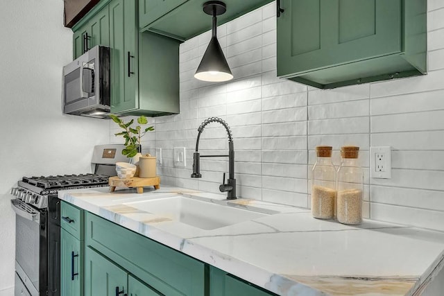 kitchen with decorative backsplash, sink, stainless steel appliances, and green cabinetry