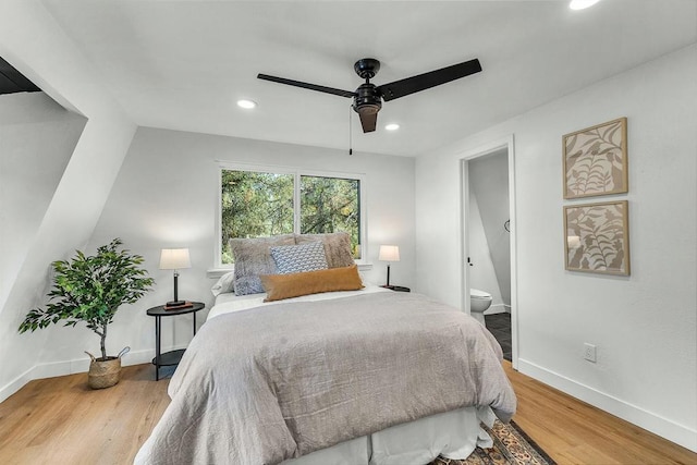 bedroom with hardwood / wood-style floors, ensuite bath, ceiling fan, and lofted ceiling