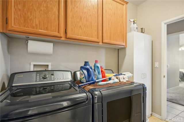 laundry area featuring light tile patterned flooring, cabinets, and separate washer and dryer