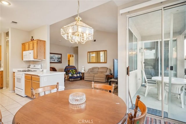 dining area featuring light tile patterned floors and an inviting chandelier