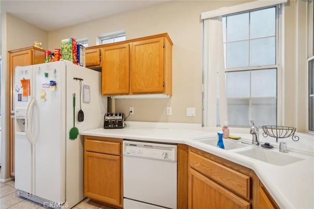 kitchen with light tile patterned floors, white appliances, and sink