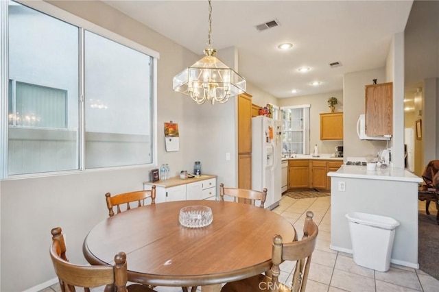 tiled dining room featuring an inviting chandelier