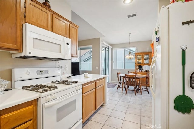 kitchen with light tile patterned floors, decorative light fixtures, white appliances, and a notable chandelier