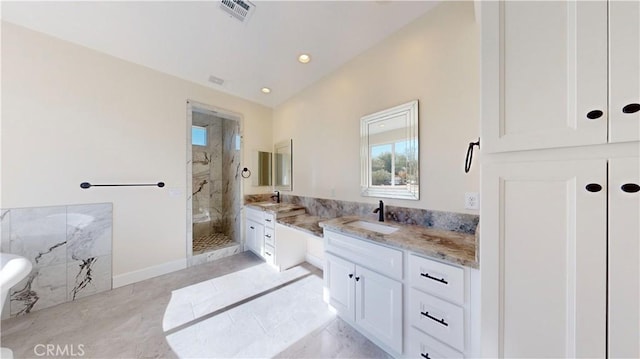 bathroom with vanity and tiled shower