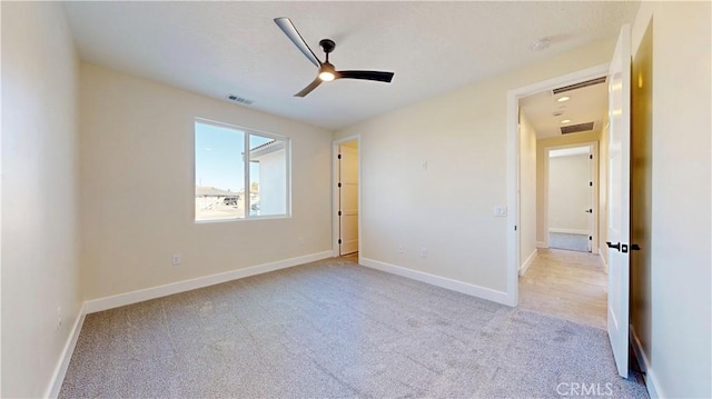 unfurnished bedroom with ceiling fan and light colored carpet