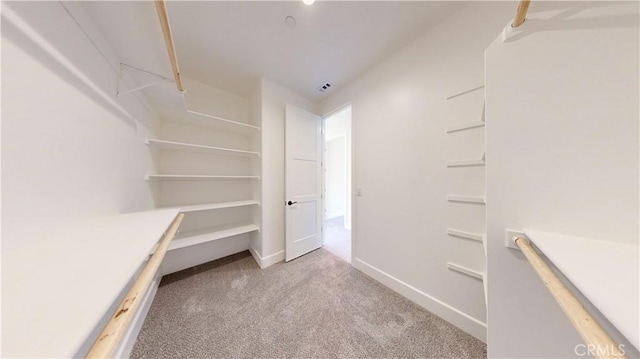 walk in closet featuring light colored carpet