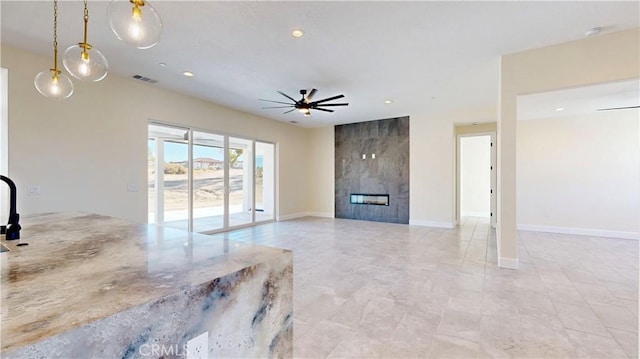 unfurnished living room with a fireplace and ceiling fan