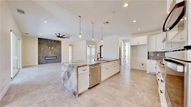 kitchen with a center island with sink, white cabinetry, and stainless steel appliances