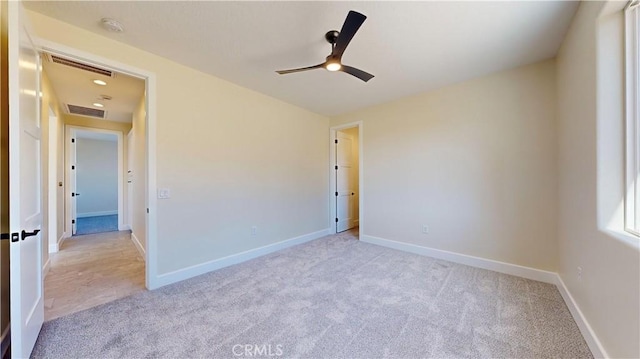 spare room featuring light colored carpet and ceiling fan