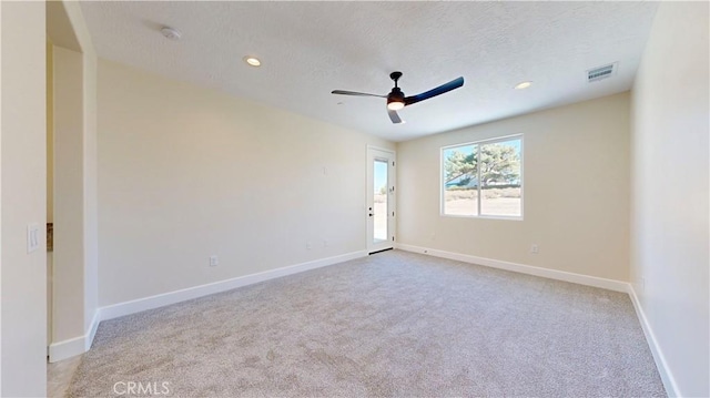 unfurnished room featuring a textured ceiling, ceiling fan, and light carpet