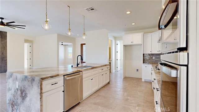 kitchen with white cabinets, pendant lighting, light stone counters, and stainless steel appliances