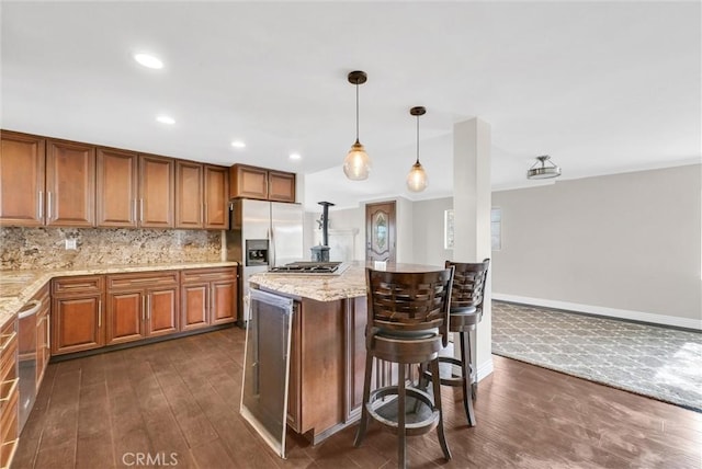 kitchen with light stone countertops, dark wood-type flooring, decorative backsplash, a breakfast bar, and appliances with stainless steel finishes