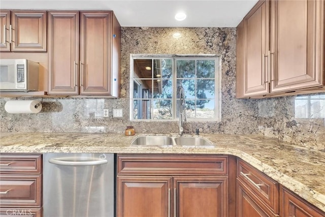 kitchen featuring dishwasher, light stone countertops, sink, and tasteful backsplash