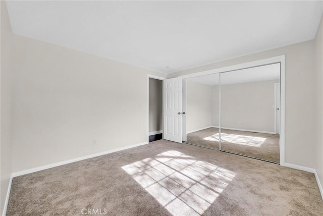 unfurnished bedroom featuring carpet flooring and a closet