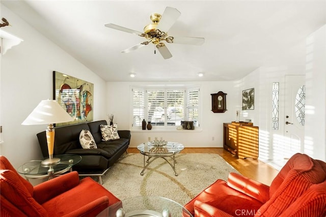 living room featuring ceiling fan, light hardwood / wood-style flooring, and vaulted ceiling