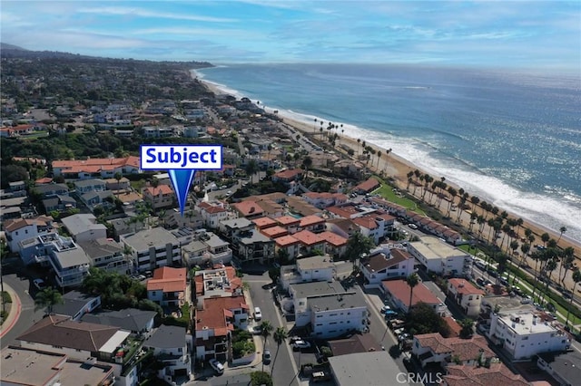 birds eye view of property featuring a water view and a beach view