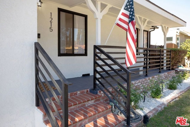 view of exterior entry featuring covered porch