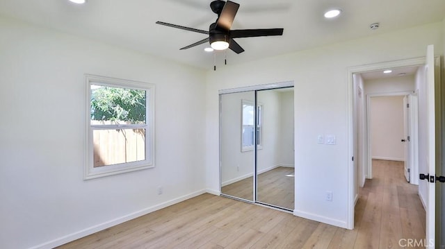 unfurnished bedroom featuring light hardwood / wood-style flooring, ceiling fan, and a closet