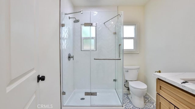 bathroom featuring vanity, tile patterned flooring, a shower with shower door, and toilet