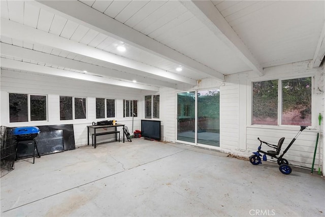 sunroom / solarium featuring beamed ceiling