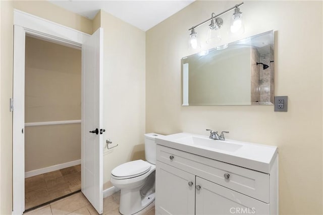 bathroom with toilet, vanity, and tile patterned floors