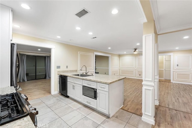 kitchen with white cabinets, black appliances, sink, ceiling fan, and ornate columns