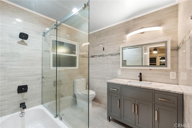 full bathroom featuring bath / shower combo with glass door, toilet, decorative backsplash, vanity, and tile walls