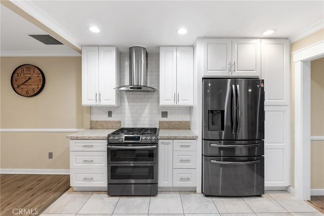 kitchen with white cabinets, wall chimney exhaust hood, and appliances with stainless steel finishes