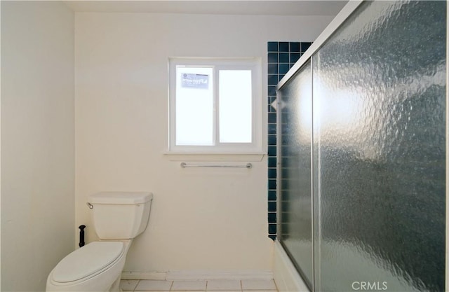 bathroom featuring shower / bath combination with glass door, tile patterned flooring, and toilet