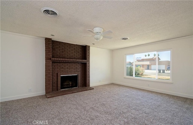 unfurnished living room featuring carpet flooring, ceiling fan, a textured ceiling, and a brick fireplace