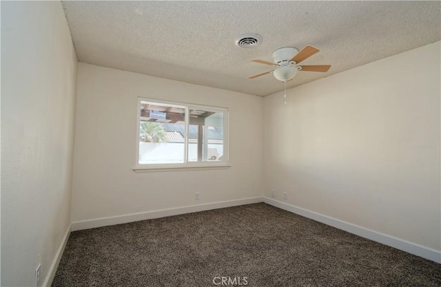 unfurnished room with a textured ceiling, dark carpet, and ceiling fan