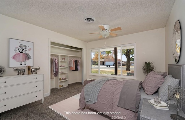 bedroom featuring dark colored carpet, ceiling fan, a textured ceiling, and a closet