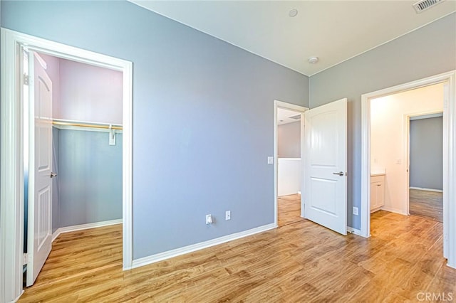 unfurnished bedroom with a closet and light wood-type flooring