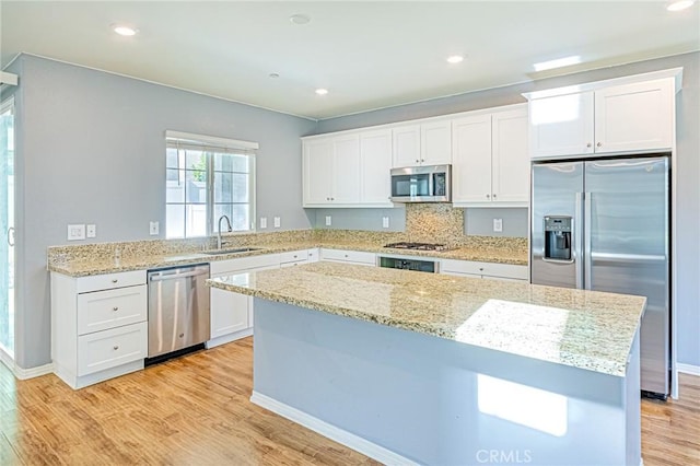 kitchen featuring white cabinets, appliances with stainless steel finishes, light hardwood / wood-style flooring, and sink