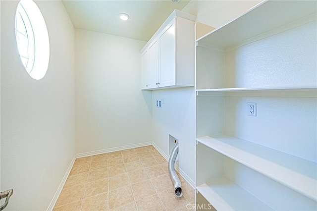 clothes washing area featuring hookup for a washing machine and cabinets