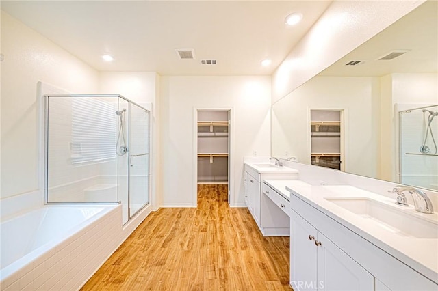 bathroom with vanity, independent shower and bath, and hardwood / wood-style flooring