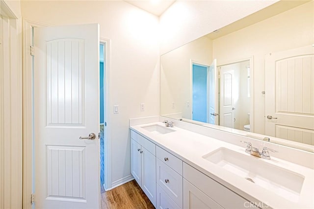 bathroom with hardwood / wood-style flooring, vanity, and toilet