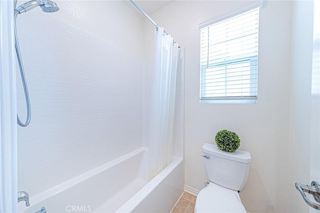 bathroom featuring tile patterned flooring, toilet, and shower / bath combo