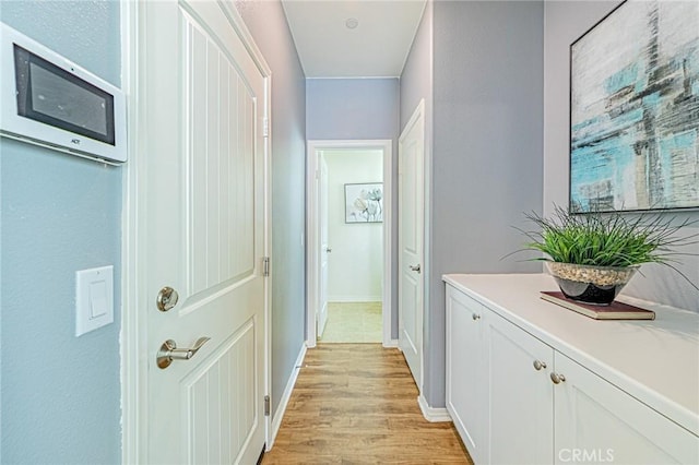 hallway with light hardwood / wood-style floors