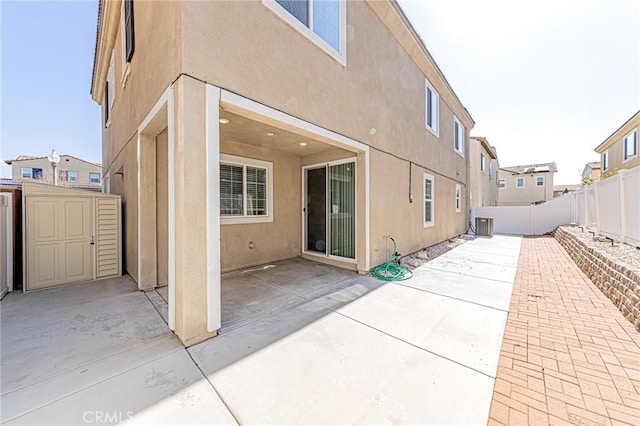 rear view of house with a patio and a storage shed