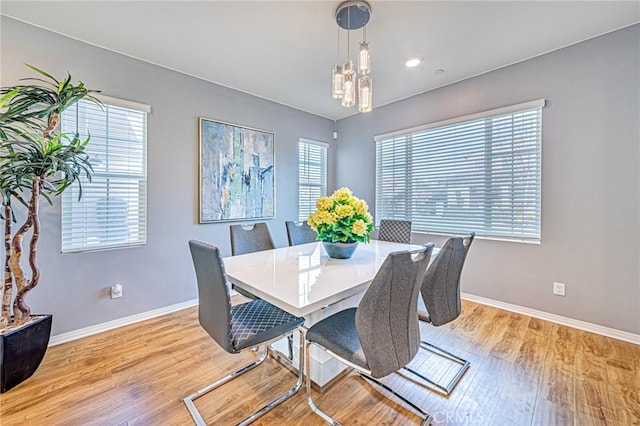 dining room with light hardwood / wood-style floors and a chandelier